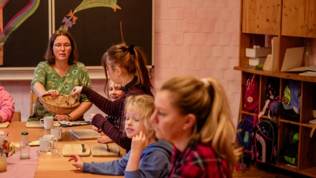 Betreuerin und Kinder beim Frühstück